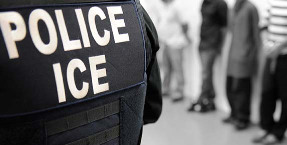 ICE officer wearing a tactical vest during an immigration enforcement operation